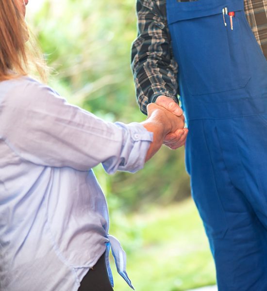 Repairman shaking hands with female customer, light effect